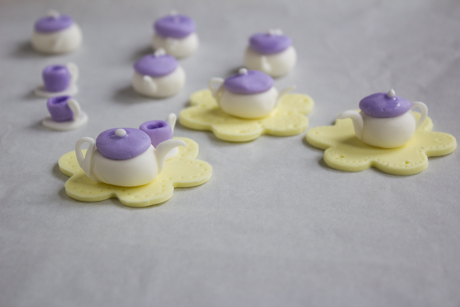 17. Place the tea cup onto the fondant cutout beside the teapot and place the entire cutout on top of the frosted cupcake. 