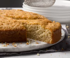 Apple Brandy Cake on a marble platter with one slice cut