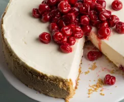 A cherry cheesecake with a slice missing