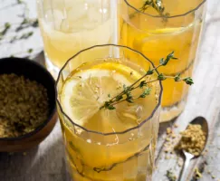 Top view of a glass of lemonade garnished with thyme