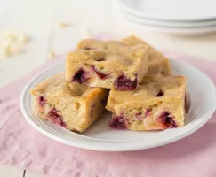 Lentil Blondies with White Chocolate and Plums stacked on a white plate
