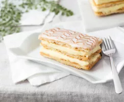 Mille Feuille cake on a plate with a fork and napkins